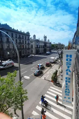 a view of a city street with people crossing the street at Hostal Orleans in Barcelona