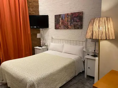 a bedroom with a bed and a tv on the wall at Hostal Orleans in Barcelona