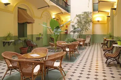 an empty restaurant with tables and chairs and plants at Hotel Peninsular in Barcelona