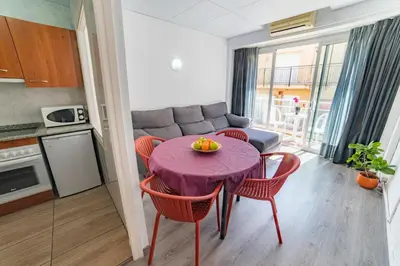 a kitchen and living room with a purple table and chairs at Apartaments Atzavara in Calella