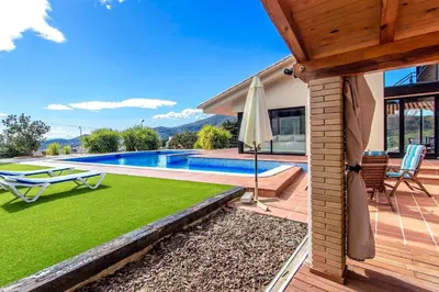 a house with a swimming pool and a patio with an umbrella at Catalunya Casas Stunning modern villa and just half hour to Barcelona! in Caldes de Montbui