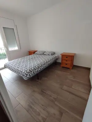 a bedroom with a bed and a wooden floor at Estancia Rural Tranquila in Lliçà d'Amunt