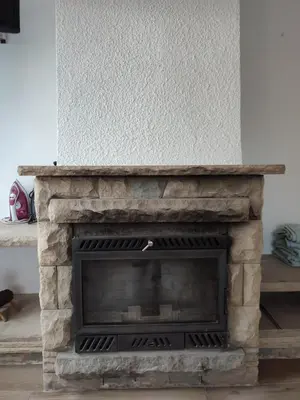 a living room with a stone fireplace at Estancia Rural Tranquila in Lliçà d'Amunt