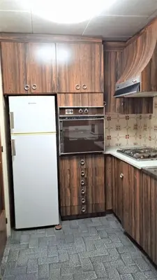 a kitchen with a white refrigerator and wooden cabinets at CALELLA DE LA COSTA ( Maresme - Costa Brava) in Calella