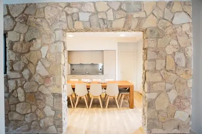 a stone wall in a dining room with a table and chairs at Can Cedre in Lliçà d'Amunt