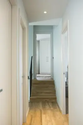 a hallway with blue walls and wooden floors at Can Cedre in Lliçà d'Amunt
