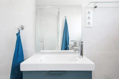 a bathroom with a white sink and a blue towel at Pis Ocata in Masnou