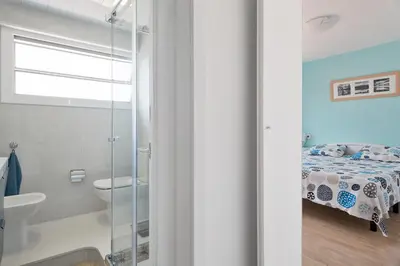 a bathroom with a shower and a bed and a sink at Pis Ocata in Masnou
