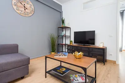 a living room with a coffee table and a clock on the wall at Lovely and Convenient Sagrada Familia Apartment in Barcelona