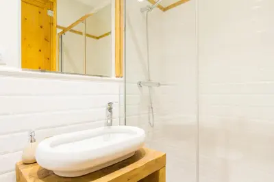 a bathroom with a white sink and a glass shower at Novus Homes Barcelona Gracia in Barcelona