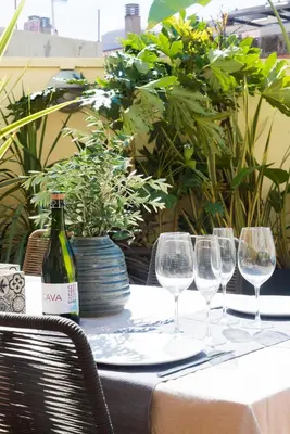 a table with wine glasses and a bottle of wine at Petit Luxe l'Oasi d'Egara in Terrassa