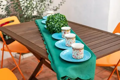 a wooden table with blue plates and cups on it at CASA FLAMINGO in Masnou