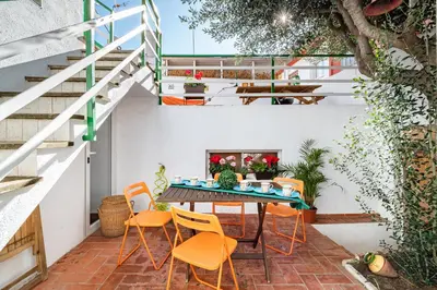 a patio with orange chairs and a table and a fireplace at CASA FLAMINGO in Masnou