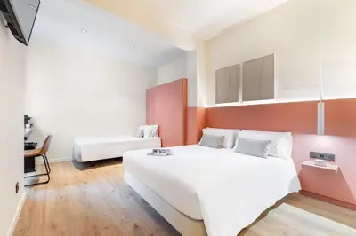 a bedroom with a large white bed and a couch at LeMar by Aspasios in Barcelona
