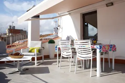 a patio with chairs and a table on a balcony at Apartament Can Mateu-Gran Terraza in Vilassar de Mar