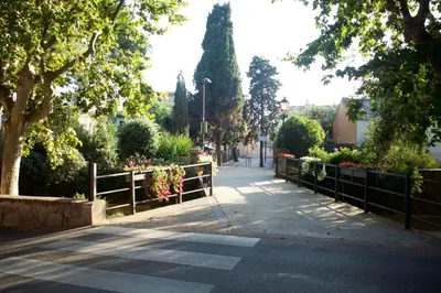 a street with a fence and some flowers and trees at Apartament Can Mateu-Gran Terraza in Vilassar de Mar