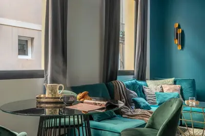 a living room with a blue couch and a table at TSA La Rosa in Barcelona