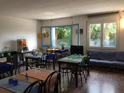 a room with tables and chairs and a couch at Hostal Santa Gemma in Sant Vicenç de Montalt