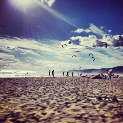a group of people flying kites on a beach at Apartment La Gavina Beach Barcelona Airport in Gavà