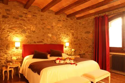a bedroom with a bed with a tray of fruit on it at Hotel Rural Can Vila in Sant Esteve de Palautordera