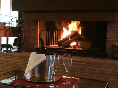 a fireplace with two wine glasses on a table at Hotel Rural Can Vila in Sant Esteve de Palautordera