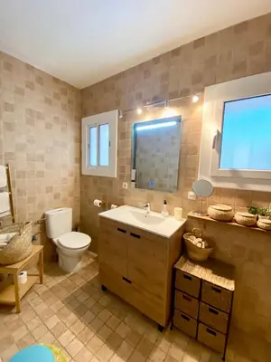 a bathroom with a sink and a toilet and a window at Seaside Apartment in Sitges Steps from Beaches with private Patio in Sitges
