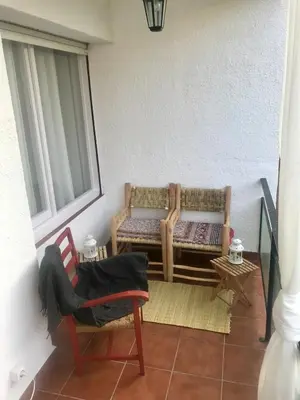 a porch with a bench and a chair and a window at Seaside Apartment in Sitges Steps from Beaches with private Patio in Sitges