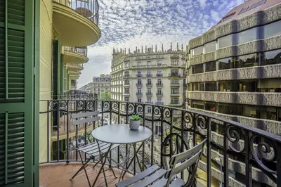 a balcony with a table and chairs and buildings at Ola Living Diagonal Apartments in Barcelona