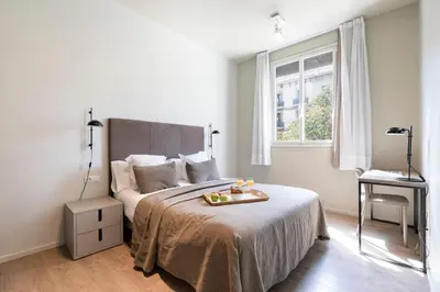 a bedroom with a bed with a tray of food on it at Aspasios Rambla Catalunya Apartments in Barcelona