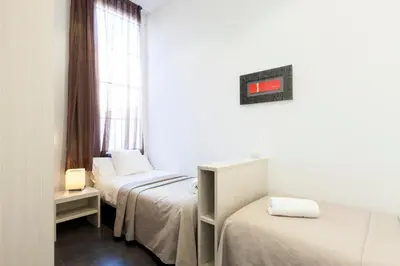 a room with two beds and a window at Aspasios Rambla Catalunya Apartments in Barcelona