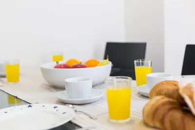 a table with orange juice and a bowl of fruit at Matarolux16 in Mataró