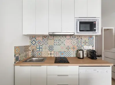 a white kitchen with a sink and a microwave at Siroco by Seaside Homes in Castelldefels