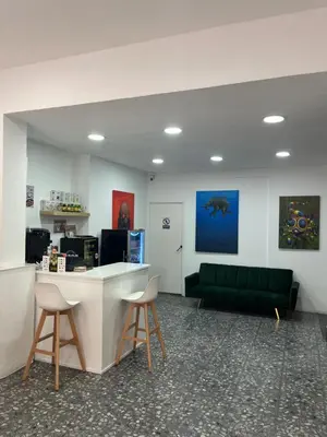 a lobby with a green couch and a counter and chairs at Hotel Ibiza in Sitges