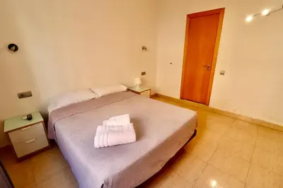 a bedroom with a bed and a wooden door at Hotel Ibiza in Sitges