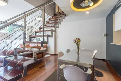 a dining room with a table and a staircase at My Space Barcelona Pool Garden Apartments in Barcelona