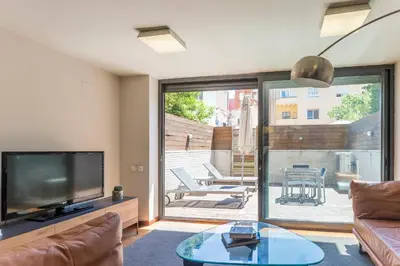 a living room with a television and a glass table at My Space Barcelona Pool Garden Apartments in Barcelona