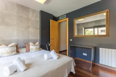 two beds in a room with a mirror on the wall at My Space Barcelona Pool Garden Apartments in Barcelona