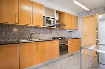 a kitchen with wooden cabinets and a sink at My Space Barcelona Executive Apartments Center in Barcelona