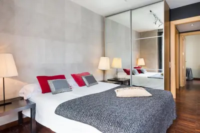 a bedroom with two beds with red pillows and a mirror at My Space Barcelona Executive Apartments Center in Barcelona