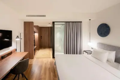 a hotel room with a large white bed and a desk at Radisson Blu 1882 Hotel, Barcelona Sagrada Familia in Barcelona