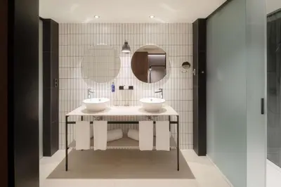 a bathroom with two sinks and a mirror at Radisson Blu 1882 Hotel, Barcelona Sagrada Familia in Barcelona