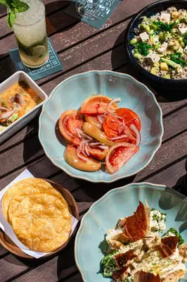 a table with plates of food on a wooden table at Radisson Blu 1882 Hotel, Barcelona Sagrada Familia in Barcelona