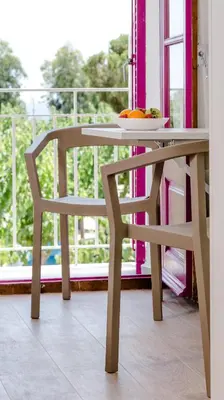 a table and a chair with a bowl of fruit on it at Bellsol Rooms in Pineda de Mar