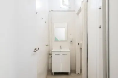 a white bathroom with a sink and a mirror at No Limit Hostel Graffiti in Barcelona