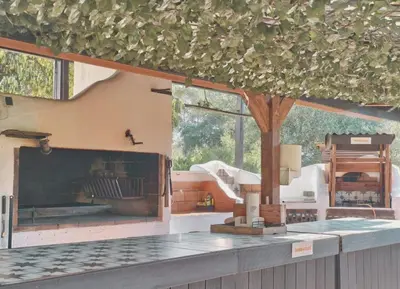 a kitchen with a large fireplace and a large window at Masía Cal Simó - Casa rural con piscina, cerca de Sitges, para celebraciones y eventos in Canyelles