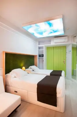 a bedroom with two beds and a skylight at Hotel Ribes Roges in Vilanova i la Geltrú