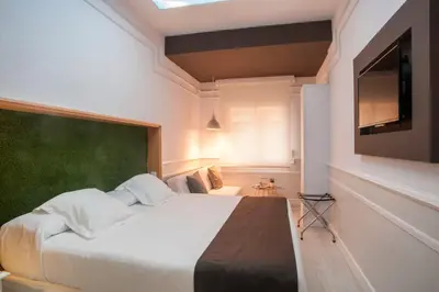 a bedroom with a large bed and a flat screen tv at Hotel Ribes Roges in Vilanova i la Geltrú