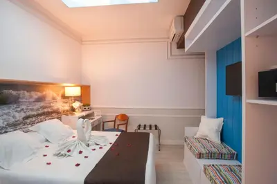a hotel room with a bed and a couch at Hotel Ribes Roges in Vilanova i la Geltrú
