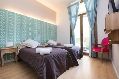 two beds in a room with blue wallpaper at Violeta Boutique in Barcelona