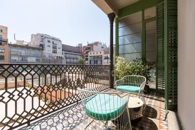a balcony with chairs and tables on a building at Violeta Boutique in Barcelona